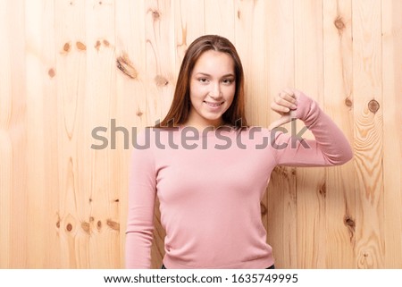 young blonde pretty girl against wood wall
