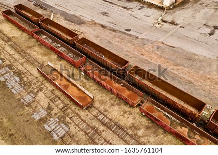 An aerial view over an abandoned train yard, with rusty train tracks and old empty box cars, in Brooklyn, NY