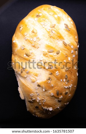 A loaf of white bread with seeds is insulated against a black background. Top views