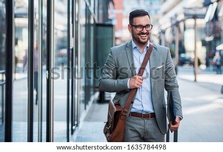 Smiling businessman with a laptop and bag on the way to office. Business, education, lifestyle concept