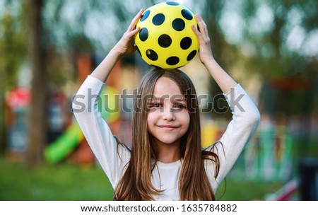 Children playground. Little girl having fun in the park with a ball