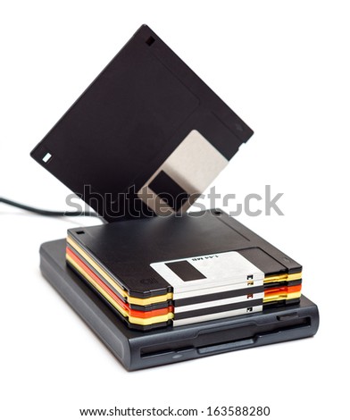 External usb floppy disk drive with disks, one standing isolated on white background