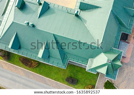 aerial top down photo of green tiled metal sloping roof with dormer windows