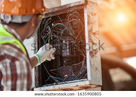 The technician is investigating the cause of the fire, short circuit, electric shock, electric control cabinet. Royalty-Free Stock Photo #1635900805