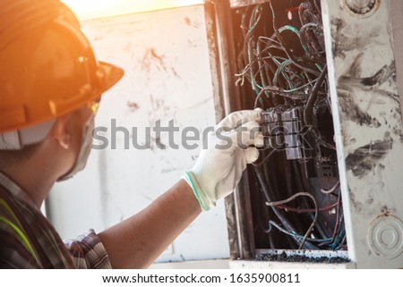The technician is investigating the cause of the fire, short circuit, electric shock, electric control cabinet. Royalty-Free Stock Photo #1635900811