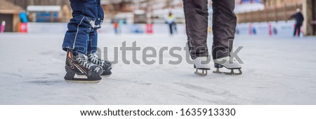 young mother teaching her little son ice skating at outdoor skating rink. Family enjoy winter on ice-rink outdoors BANNER, LONG FORMAT