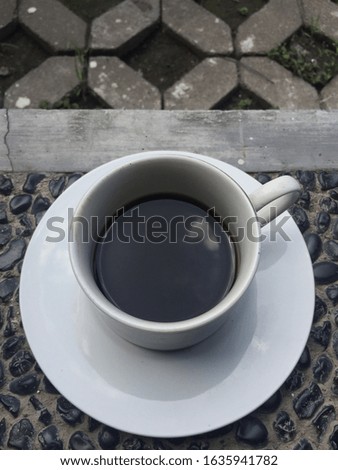 A cup of black coffee served in a white glass cup adds to the delicious serving of warm mornings