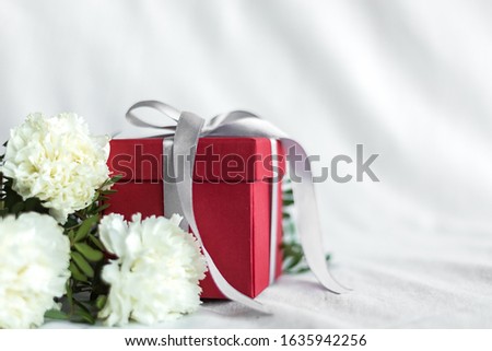 Bouquet of flowers and gift box birthday, Happy mother's Day and Valentine's day on a white textile background. Gift card. Selective focus. copy space