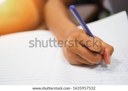 Writing class concept, selective focused picture of hand using pen or pencil working on test or class assignment at the training center, education or academic concept image of student in lecture room