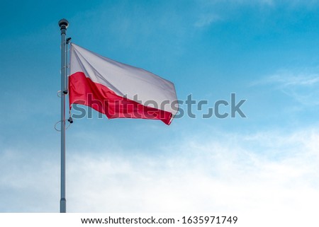 flag of Poland on the background of a blue sky is developing, the national symbol of Poland