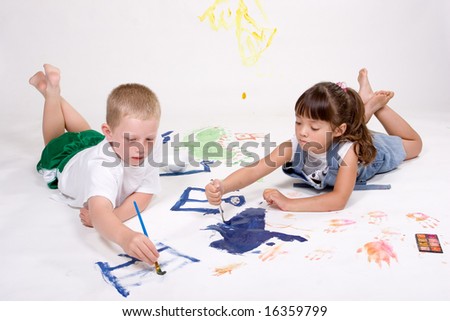 Two kids are painting on large white paper.