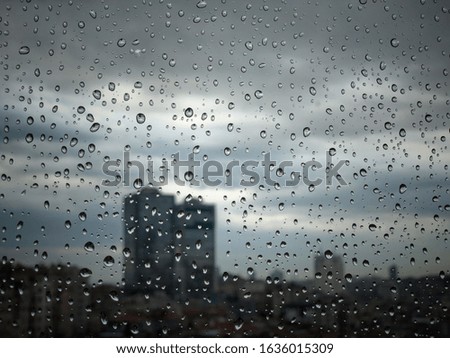 rain drops on window pane against city view