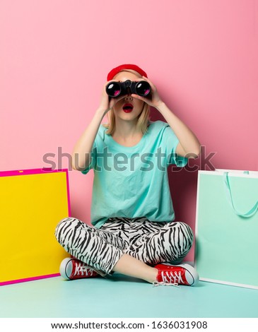Style woman with shopping bags and binoculars on pink background
