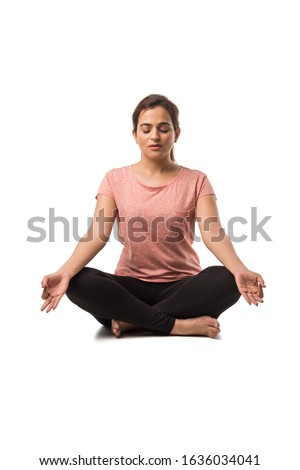 Indian Woman / Girl performing Yoga asana or meditation or dhyan, sitting isolated over white background Royalty-Free Stock Photo #1636034041