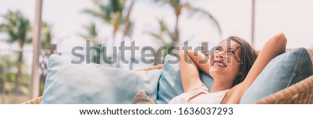 Lifestyle relax happy Asian woman on sofa luxury hotel living banner panoramic. Comfort home summer travel vacation free girl breathing clean air on summer destination panorama. Royalty-Free Stock Photo #1636037293