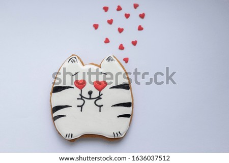 love cat made of gingerbread dough with heart-shaped eyes on a white background with hearts, a gift for February 14, Valentine's Day