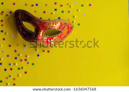 Festive mask with decor on a yellow background. Carnival celebration concept, Mardi Gras, Brazilian carnival, Venice carnival, carnival costume, spring. Flat lay, top view, place for text