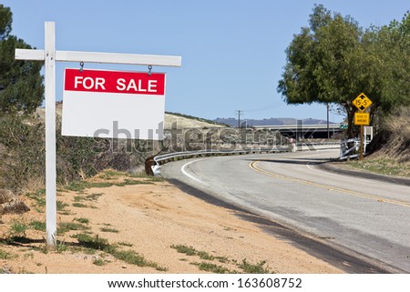 Sale sign hangs off a wooden post in a rural scene. 