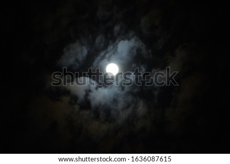beautiful picture of full moon in the dark. Dramatic clouds in the moonlight.