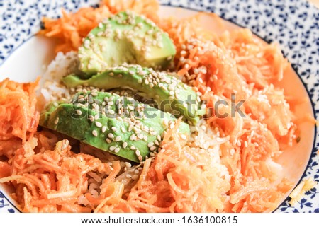 Apple and carrot salad with avocado and sesame seeds.
