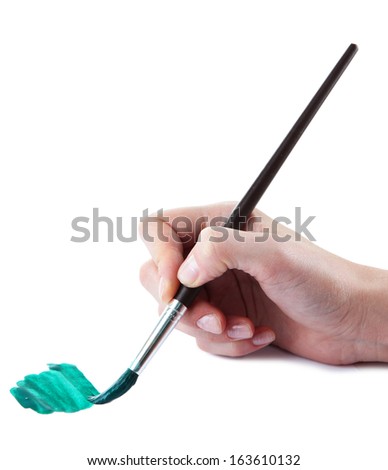 Hand holding brush with green paint isolated on white