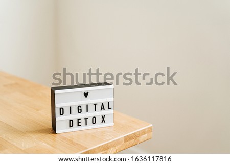 Digital detox day. Lightbox on wooden background and white walls. Gadget ban