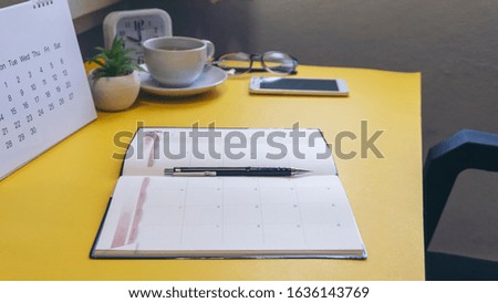 Diary,Calendar and agenda for Planner to plan timetable,appointment,organization at office.Desktop Calender 2020,smartphone,clock,book and cup of coffee place on desk.Calendar Background Concept.