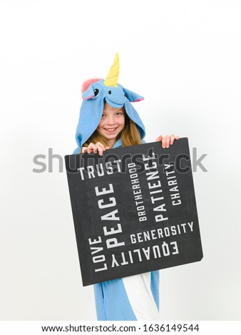 pretty blonde girl with cozy blue unicorn costume with blackboard with words on it written