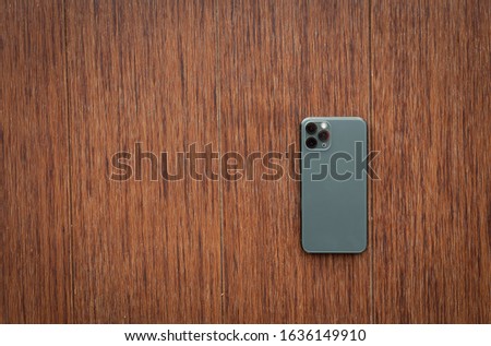 back smartphone on wooden desktop. Top view