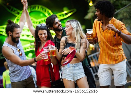Group of happy friends hanging out and enjoying drinks, festival