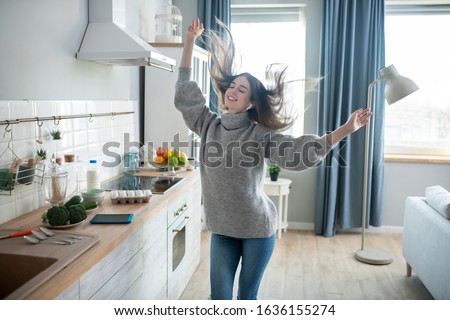 Fun time. Dark-haired girl in a grey sweater having fun at home Royalty-Free Stock Photo #1636155274