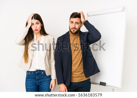Young caucasian business couple isolated tired and very sleepy keeping hand on head.