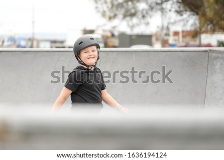Young boy wearing skate helmet playing at the skate park in Portland, Victoria Australia