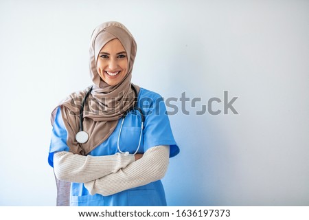 Closeup portrait of friendly, smiling confident muslim female nurse. Authentic Confident Middle Eastern Healthcare Worker. Middle age senior arab nurse woman wearing hijab over isolated background Royalty-Free Stock Photo #1636197373