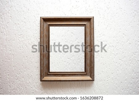 One empty wooden frame on a white wall background texture, retro modern design space for text