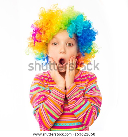 surprised little girl in clown wig isolated on white background