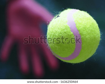 An extreme closeup slow motion action capture of a tennis ball By using the hand to throw the ball away Take pictures while moving