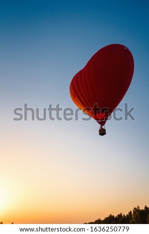 A balloon in the shape of a heart. Flying in a hot air balloon