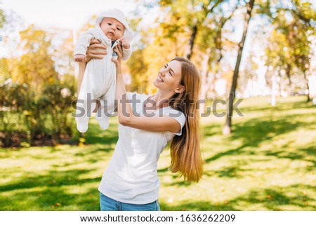 Mother and newborn baby. A mother holds her young son in her arms while walking in the Park in Sunny weather. Mother's day