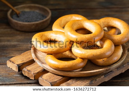 Bagels on a wooden plate on a brown wooden table. Rustic style. Homemade cake. Top view with space for text	