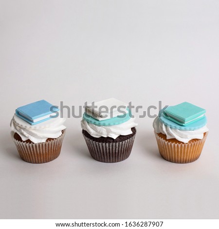 Cupcake with sugar books on top, on the grey paper background, daylight