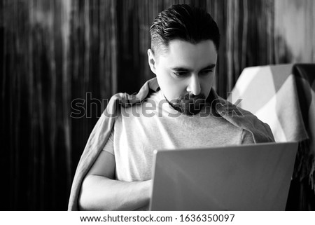 Picture caucasian man with fuzzy beard enjoying online communication via social networks, surfing dating websites using high speed wireless internet connection at home