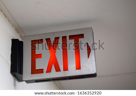 red emergency exit sign in the dark room. illuminated office exit sign