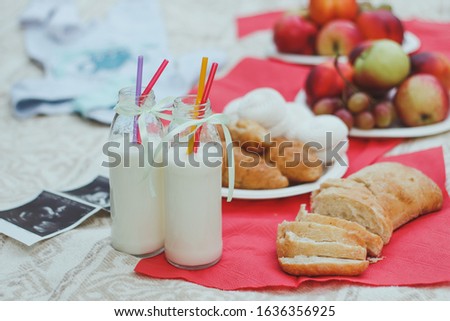 Picnic on green background in the garden. Balanced diet during pregnancy. Ultrasound baby. Pregnancy, maternity, preparation and expectation concept. Beautiful tender mood photo of pregnancy.