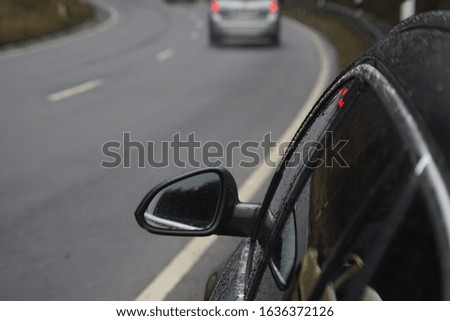 Drive by Car at the Road with a near parking Car with seeing the Mirror