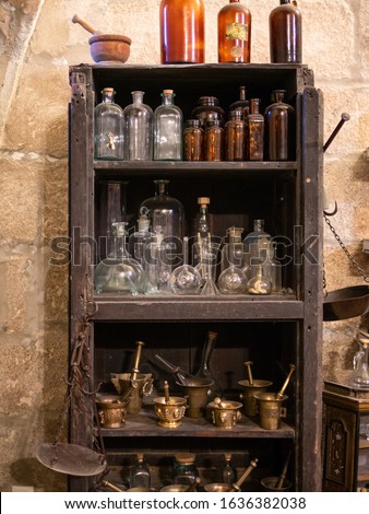 old shelf filled with old and antique bottles, alchemy concept Royalty-Free Stock Photo #1636382038
