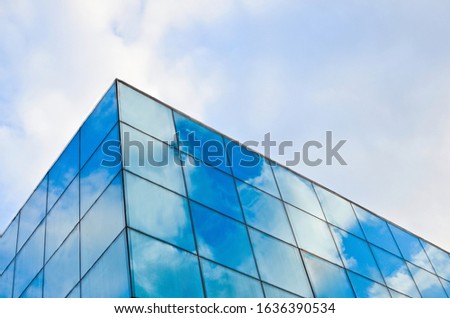 Abstract background for business purposes. Blue sky with white clouds reflected in the windows
