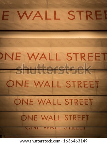 Red color One Wall Street sign on yellow surface in a row in NYC.