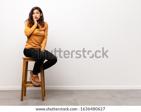 young pretty woman scheming and conspiring, thinking devious tricks and cheats, cunning and betraying sitting into a room Royalty-Free Stock Photo #1636480627