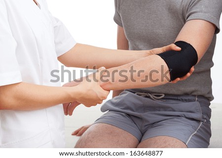 Examination of injured elbow of tennis player Royalty-Free Stock Photo #163648877